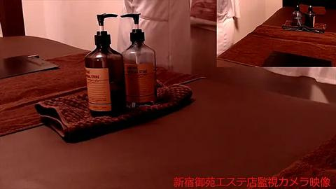 Media: Video of a spa room featuring a massage table with brown towels, a bottle of massage oil, and a Japanese text overlay.