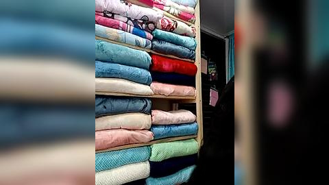 Media: Video of neatly stacked fabric rolls in various pastel colors, including pink, blue, and green, displayed in a well-lit room with a blurred background.