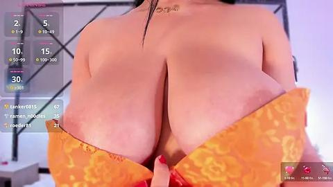 Media: A video of a woman with large, bare breasts in a yellow, floral-patterned bra, seen from behind. The background is a modern room with a bed, and a smartphone screen displaying social media stats.