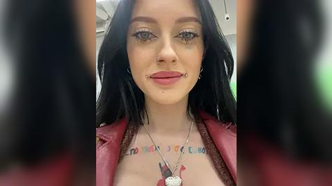 Media: Video of a young woman with fair skin, long black hair, and a nose ring, wearing a red leather jacket and a necklace with a dog tag.