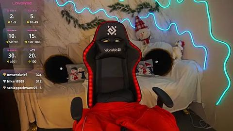 Media: Video of a gamer in a red gaming chair, facing a Christmas-themed bedroom with LED lights, snowman decor, and a bed adorned with festive pillows.