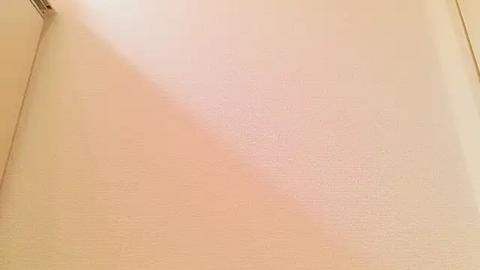 Media: A video of a beige wall with a slightly textured surface, featuring a light, soft pink reflection at the center. The image lacks visible objects or people, focusing solely on the wall's neutral color and subtle lighting.