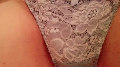 Media: Close-up video of a woman's lower torso in light gray lace lingerie, featuring floral patterns, against a tan skin tone.