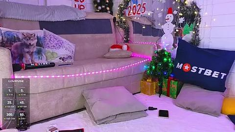 Media: Video of a festive living room with a beige couch, a Christmas tree, a Santa snowman, and a \"mama\" sign.