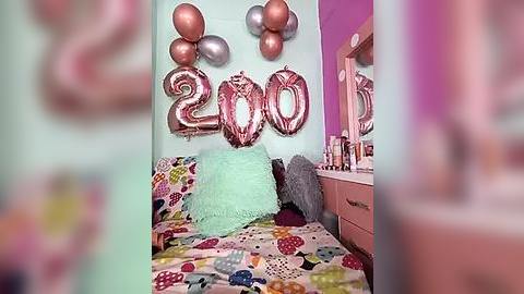 Media: Video of a girl's room with pastel mint green walls. Decorated with 300 gold balloons, a pink furry pillow, and a colorful bedspread.