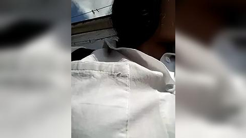 Media: A blurry video of a person in a white shirt, partially obscured by a shadow, suggests an outdoor setting with a blue sky visible in the background.