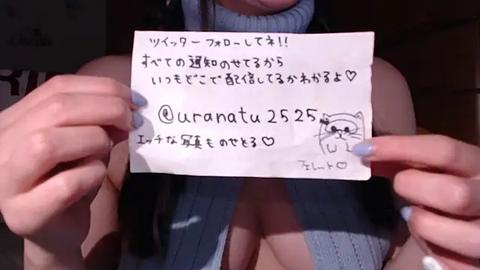 Media: A video of a woman holding a handwritten note featuring Japanese text, with her cleavage partially visible in a light blue top.