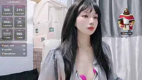 Media: Video of a young Asian woman with long black hair, wearing a gray blouse revealing a pink bra, standing indoors with a digital display showing her weight and heart rate.