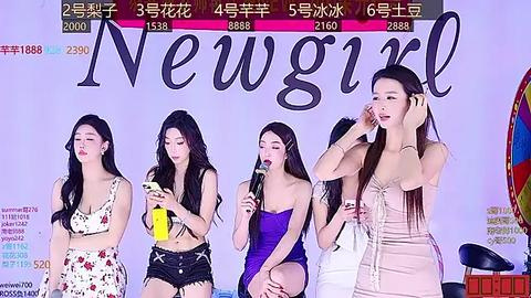 Media: Video of four young Asian women, dressed in casual, colorful summer outfits, singing into microphones on a stage with \"New Girl\" banner.