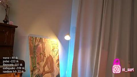 Media: A video of a room with a nude, abstract painting, a lit lamp, and a partially visible white curtain. The image includes a watermark with social media icons.