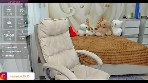 Media: Video of a cozy, child-friendly bedroom with a plush, beige recliner chair, a brown knitted blanket on a white bed, and stuffed animals including a teddy bear and a bunny.