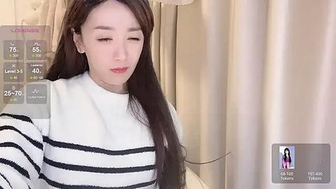 Media: Video of an Asian woman with long, straight brown hair wearing a black-and-white striped sweater, standing in front of beige curtains, with virtual fitness app overlay showing steps, distance, and calories.