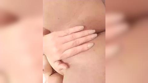 Media: A close-up video of a woman's hand gently cupping her bare breast, with a blurred background. The skin is fair, and the lighting is soft, highlighting the natural texture and contours of the breast.