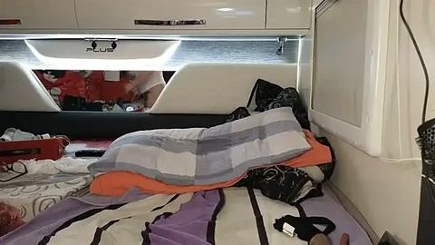 Media: Video of a messy cabin on a yacht, featuring disheveled bedding, scattered clothes, and a partially visible person sleeping under a striped blanket.