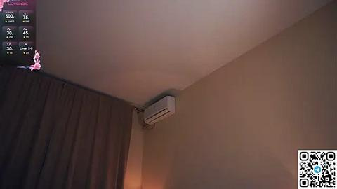 Media: A video of a beige wall with a mounted white air conditioning unit, partially covered by a dark curtain on the left. A QR code and a screen displaying a thermometer are visible in the top left corner.