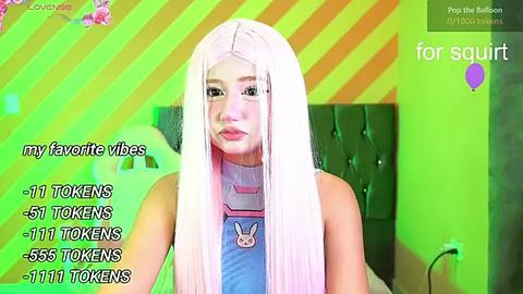 Media: A bright, vibrant video of a young woman with long, straight, platinum blonde hair, wearing a blue jumpsuit with a bunny motif. The background features a neon green and yellow striped wall. Text overlays list TikTok views and followers.