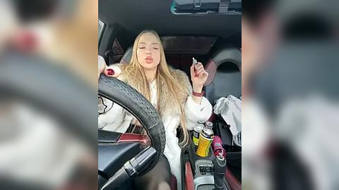 Media: Video of a blonde woman in a white fur coat, smoking a cigarette in a car with a red interior. Background is blurry, focusing on her casual, relaxed expression.