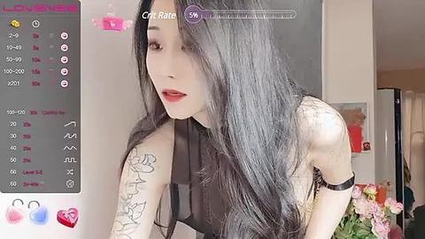 Media: Video of an East Asian woman with long, straight black hair, wearing a black sleeveless top, featuring detailed tattoos on her left arm. The background includes a pink bouquet and a window.