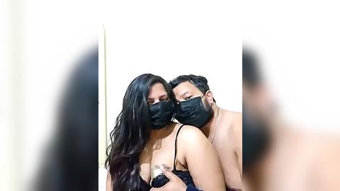 Media: A video features two individuals, a man and a woman, wearing black masks, leaning close, with a blurred background.