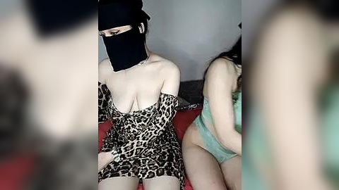 Media: Video of two women in lingerie; one in leopard print, the other in turquoise, both wearing black masks.