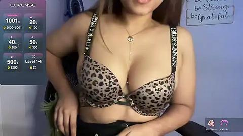 Media: A video of a light-skinned woman with long brown hair, wearing a leopard-print bra with \"LOVE\" and \"SEX\" inscriptions, standing indoors with a blue wall and motivational quote.