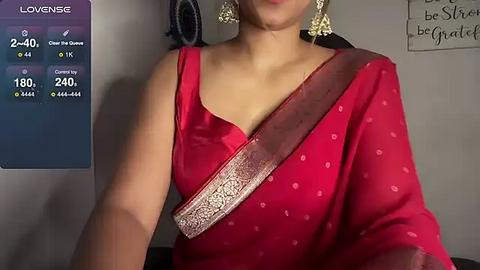 Media: A video of a South Asian woman wearing a red sari with a gold border, adorned with gold earrings, standing in a dimly lit room with a \"Love Sense\" app interface on the left.