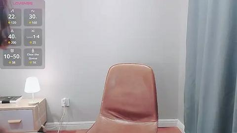 Media: Video of a minimalist office corner featuring a tan leather chair, a small white desk lamp, and a light blue curtain. The wall displays a \"Loose Fit\" schedule with temperature readings.