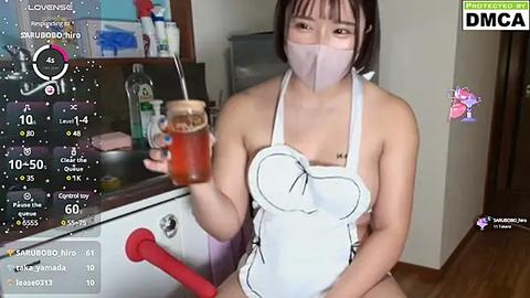 Media: A video of an Asian woman in a maid outfit, face masked, holding a glass of iced tea. The background features a kitchen with white tiles and a wooden floor.