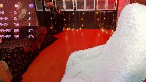 Media: Video of a cozy, dimly lit room with a plush white chair, a red carpet, and a wall adorned with fairy lights and a large, colorful mural.