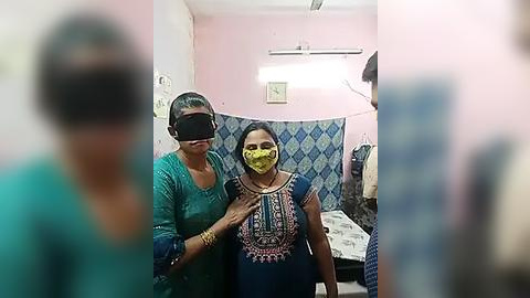 Media: Video of two women in a medical room, one wearing a head-mounted device, the other with a yellow mask, pastel-colored walls, and a blue-patterned curtain.