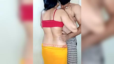 Media: Video of an intimate moment between a woman and a man in a red bra, yellow skirt, and checkered pants.