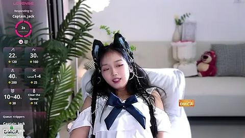 Media: A video of a young Asian woman in a white sailor outfit, sitting on a couch, with a live stream overlay showing viewer counts and chat.