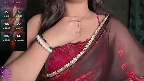 Media: A close-up video of a woman in a red, embroidered saree, with a white bracelet on her wrist. The background shows a virtual thermometer reading \"Lowense\" and \"Highense.\