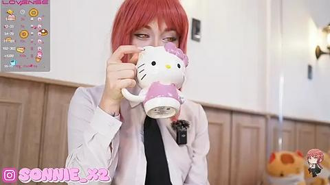 Media: Video of a red-haired woman in a white lab coat holding a Hello Kitty mug, with a watermark overlay of \"Lovenese x Sonnie\" and a smaller image of Sonnie in the corner.