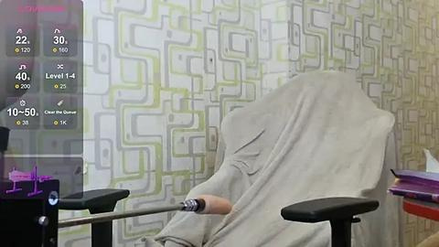 Media: Video of a person in a hospital gown sitting in a wheelchair, surrounded by modern, geometric-patterned wallpaper and medical equipment.
