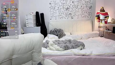 Media: A video of a minimalist, cluttered bedroom with a white bed, gray blanket, black guitar, and white wall art.