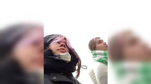 Media: A video of three blurred women in winter coats and scarves, taken from a low angle, emphasizes their faces and expressions.