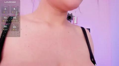 Media: Video of a woman's bare shoulders and upper chest, wearing a black bra, with a thermometer and calendar overlay on the left, displaying 20\u00b0C.