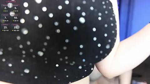 Media: A close-up video of a woman's black polka-dot bra, with a partially visible blue background, and a \"LOVING\" text overlay.