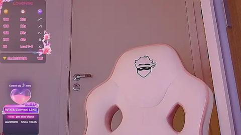 Media: Video of a pink gaming chair with a black mask logo, set in a dimly lit room with a purple digital display showing Twitch stats and a wooden wall in the background.