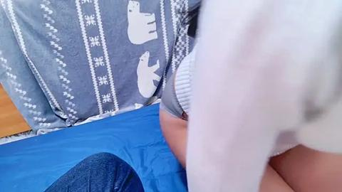 Media: A video showing a person in a blue and white patterned shirt bending over a blue mat, with a close-up of their back and part of their arm visible.