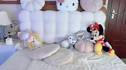 Media: Video of a plush Disney-themed nursery with white bedding, a wooden headboard, and soft toys including Minnie Mouse, Donald Duck, Goofy, and a white rabbit.