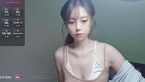 Media: Video of a young, slender East Asian woman with fair skin, wearing a white bra and an off-shoulder top, indoors with a green wall. Left screen shows health stats.