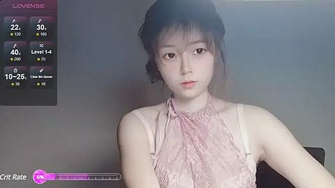 Media: Video of a young Asian woman with fair skin, wearing a pink lace blouse, seated indoors. Left side displays a virtual game interface with stats and \"Crt Rate\" at the bottom.