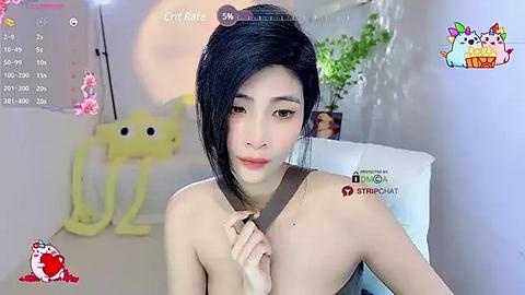 Media: A video of an East Asian woman with long black hair, fair skin, and a slender build, wearing a strapless dress, standing in a modern room with white walls, plants, and a yellow plush toy.