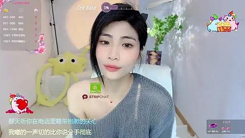 Media: A video of an Asian woman with black hair, wearing a grey sweater, sitting in a bright room with a City Place live stream overlay, showcasing a playful, casual atmosphere.