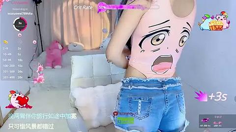 Media: A video of a young woman with light skin and long, dark hair, wearing a pink crop top and denim shorts, standing in a cozy room with pink decorations and a plush bear.