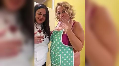 Media: Video of a nurse and a plus-sized blonde woman in a pink bra and green polka-dotted apron, both smiling, in a bright yellow room.