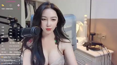 Media: Video of an Asian woman with long black hair, wearing a revealing white lace bra, recording herself on a camera in a bedroom.