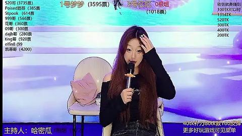 Media: A young Asian woman with long hair sings into a microphone while seated on a white chair. She wears a black top and jeans. The background features a large screen displaying live stats and Chinese text.